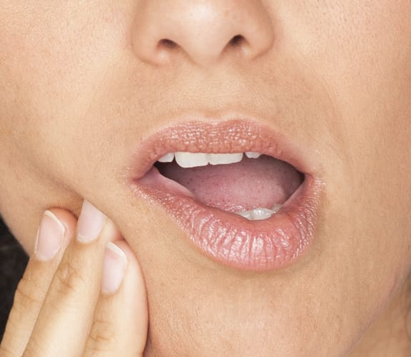 Woman holding her mouth in pain