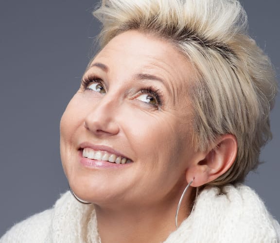 Woman with short hair looking up and smiling
