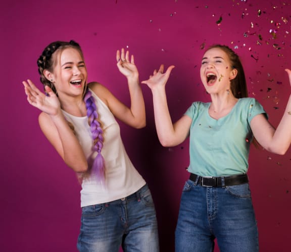 Two girls throwing confetti in the air